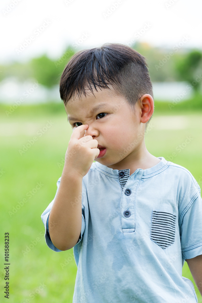 Little boy holding his nose of bad smell