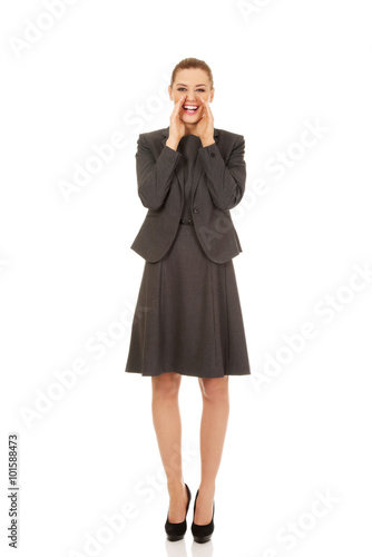 Young smiling business woman screaming loud or calling someone