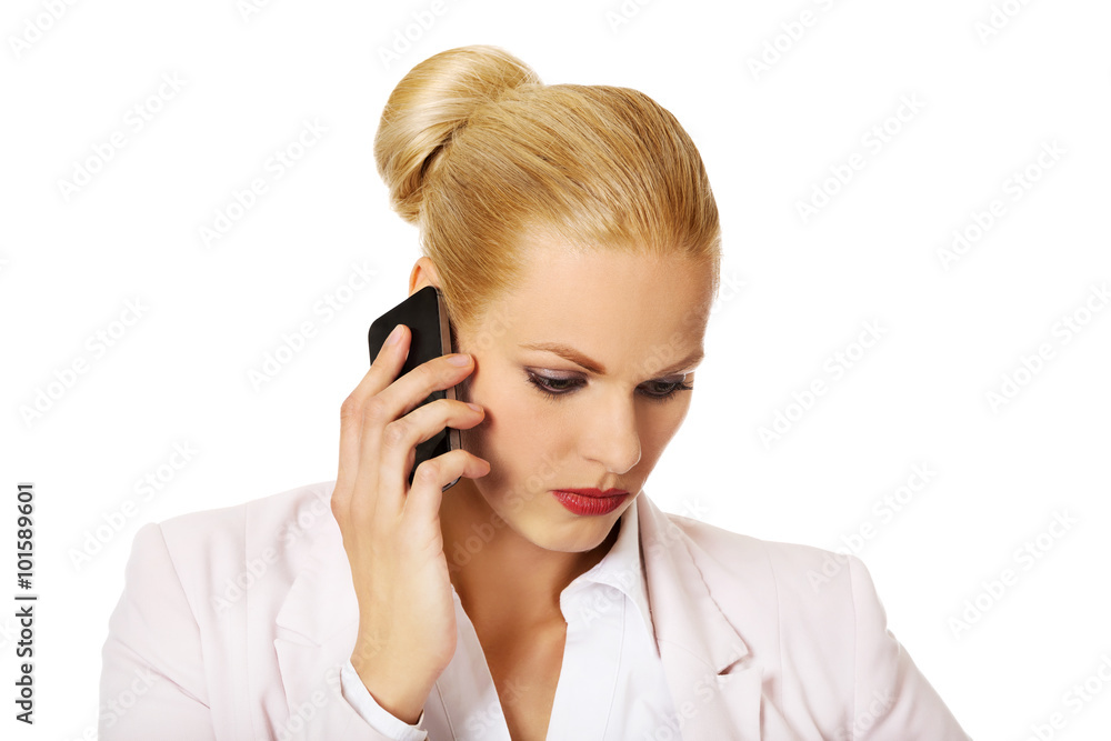Serious business woman talking through a mobile phone Serious business woman talking through a mobile phone