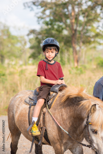 Little boy riding training horse