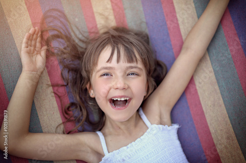 happy little girl on a rainbow hammock photo
