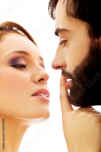 Woman putting her finger on man's lips