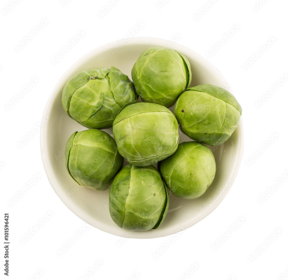 Brussels sprouts in white bowl over wooden background Brussels sprouts in white bowl over wooden background
