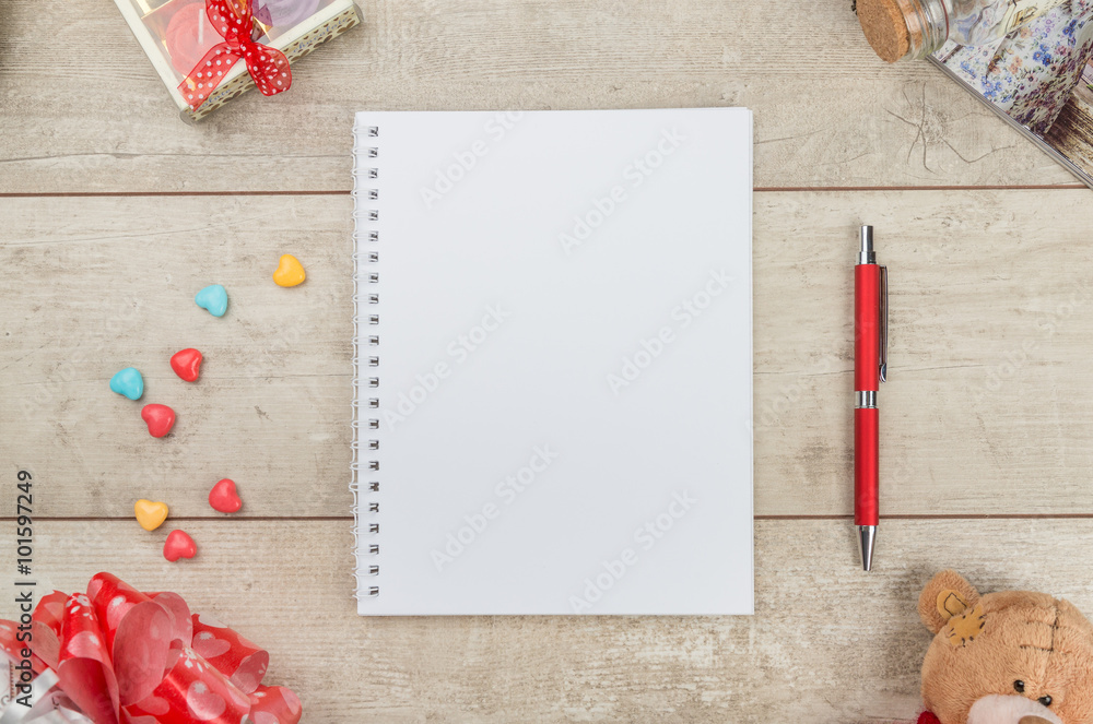 Notepad, pen, candy and teddybear on wooden table Notepad, pen, candy and teddybear on wooden table