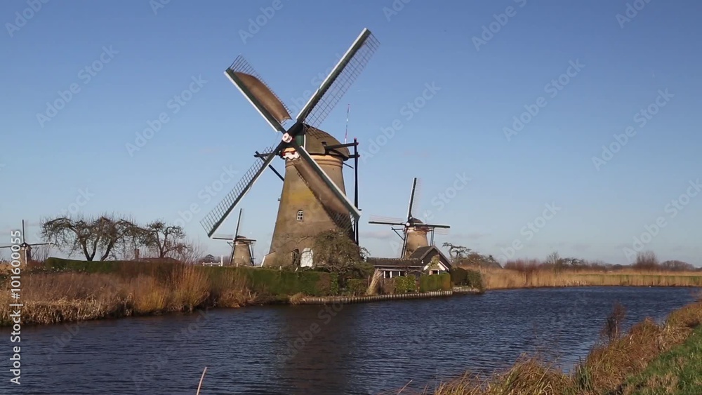 Turning Dutch windmill on blue sky, Unesco World Heritage Site Kinderdijk, Netherlands Turning Dutch windmill on blue sky, Unesco World Heritage Site Kinderdijk, Netherlands