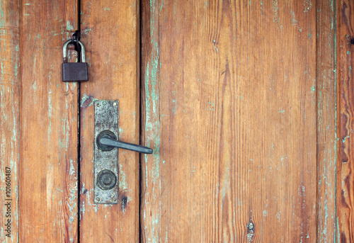 Old weathered wooden doors with rusty door handle and padlock