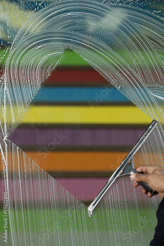 window cleaner using a squeegee to wash a window