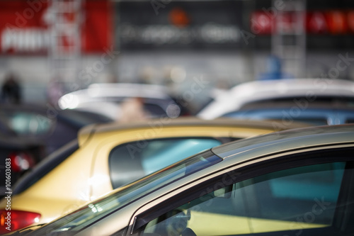 Close-up of cars on blur bokeh background. Cars in the parking lot. Shallow depth of field. Selective focus.