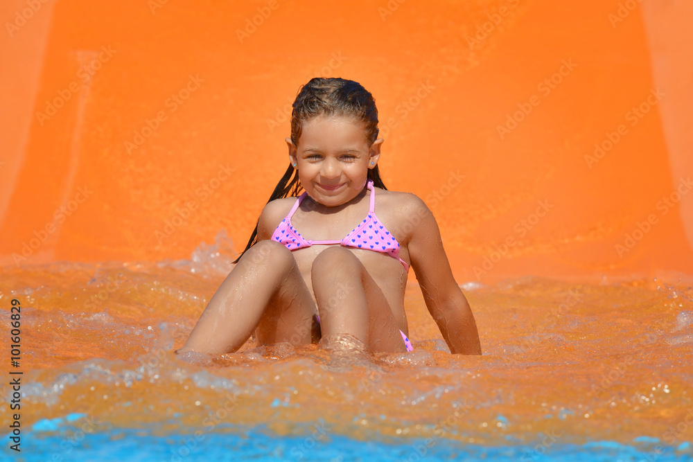 Adorable toddler girl on water slide at aquapark Adorable toddler girl on water slide at aquapark