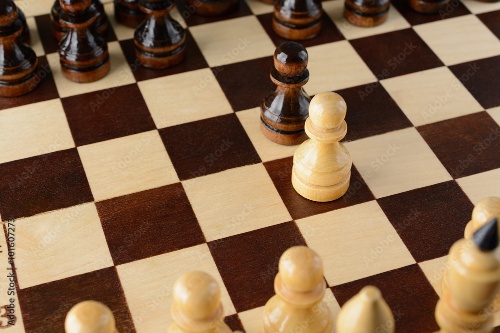 Black and white pawns facing each other Black and white pawns facing each other