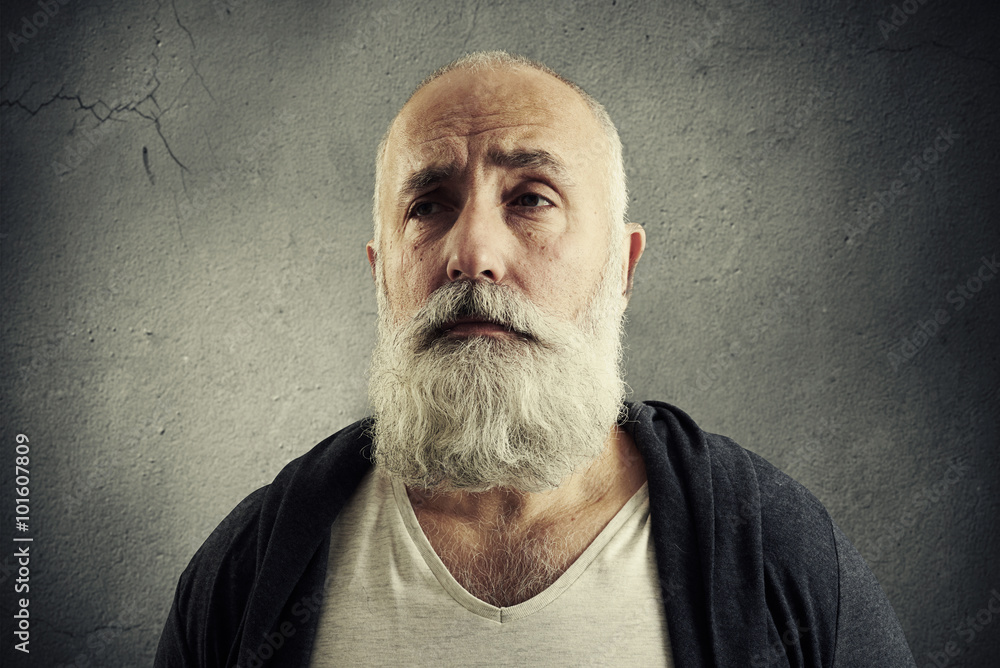 Fotografia doleful senior man over dark wall