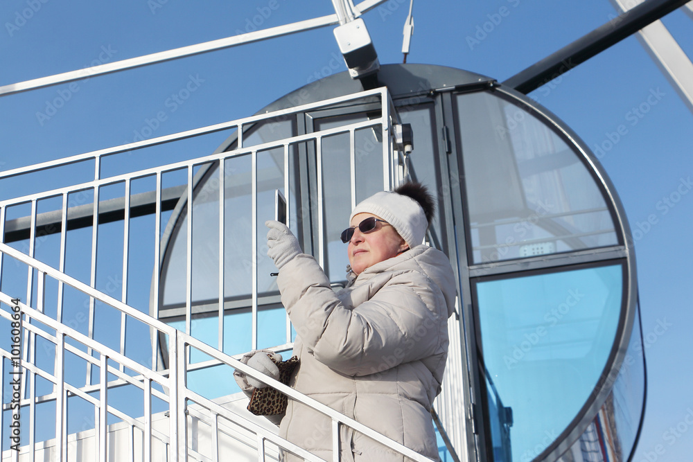 The woman in a white cap and dark glasses photographing phone a cabin devil's wheels
The woman in a white cap and dark glasses photographing phone a cabin devil's wheels