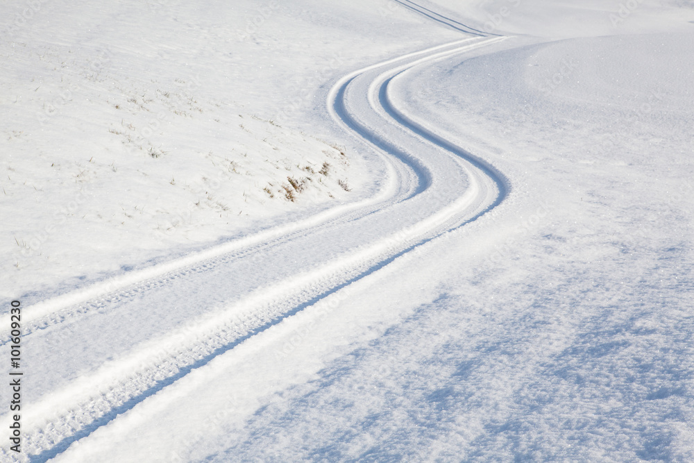 Car tire track on winter road