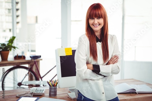 Smiling hipster businesswoman with arms crossed
