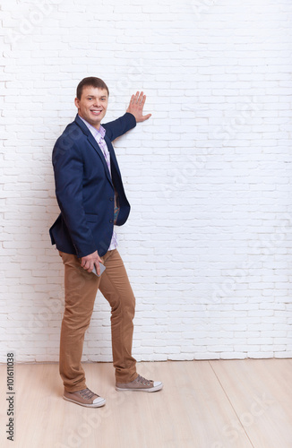 Young Man Hand On Wall Gesture To Copy Space Full Length 