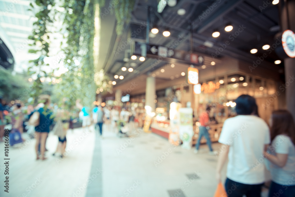 blurred image of  Interior of modern mall with some people in it