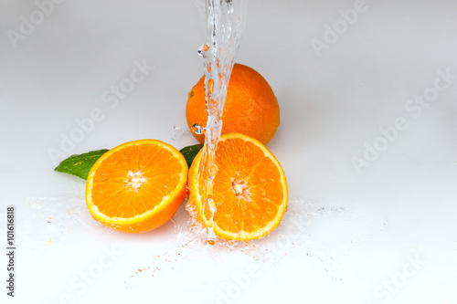 pomarańcze polane wodą na białym tle