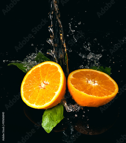 Pomarańcze polane wodą na czarnym tle