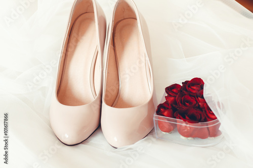 wedding shoes with rings and red rose petals