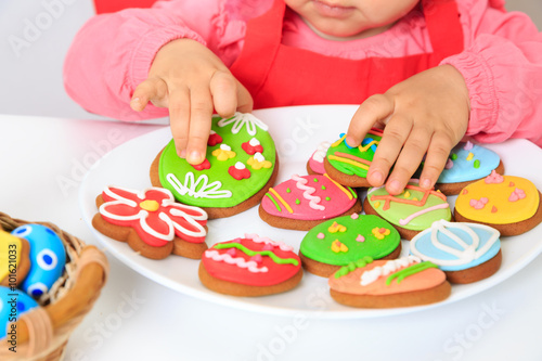 little girl playing with easter cookies