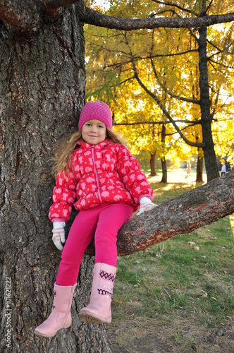 Девочка 5 лет сидит на ветке дерева