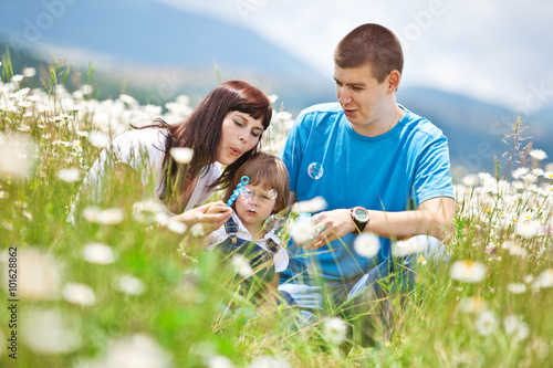 Happy family in a camomile field 