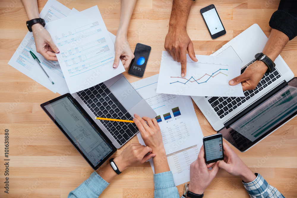 Team working for financial report using laptops and smartphones Team working for financial report using laptops and smartphones