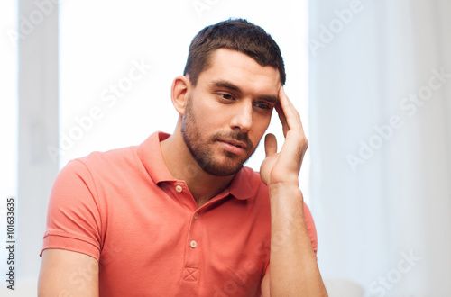 unhappy man suffering from headache at home