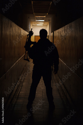 Anti terrorist standing with a gun in the dark corridor