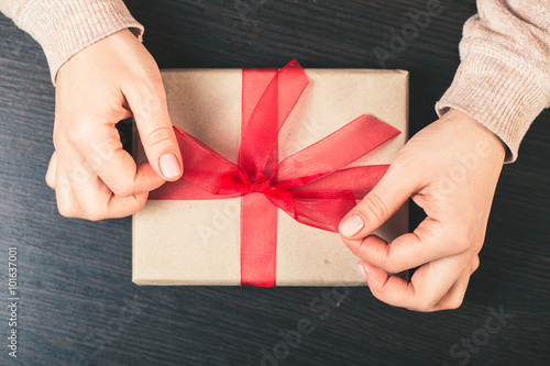 girl holding a gift box. Manicure gel nail photo