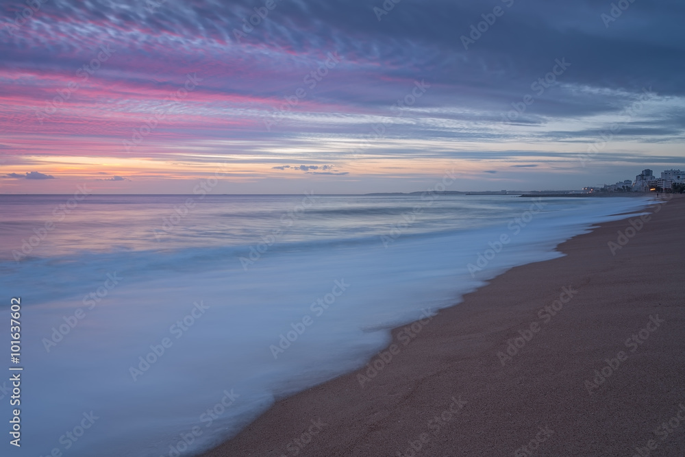 Pink sunset on the beach in Quarteira. Portugal for tourists.