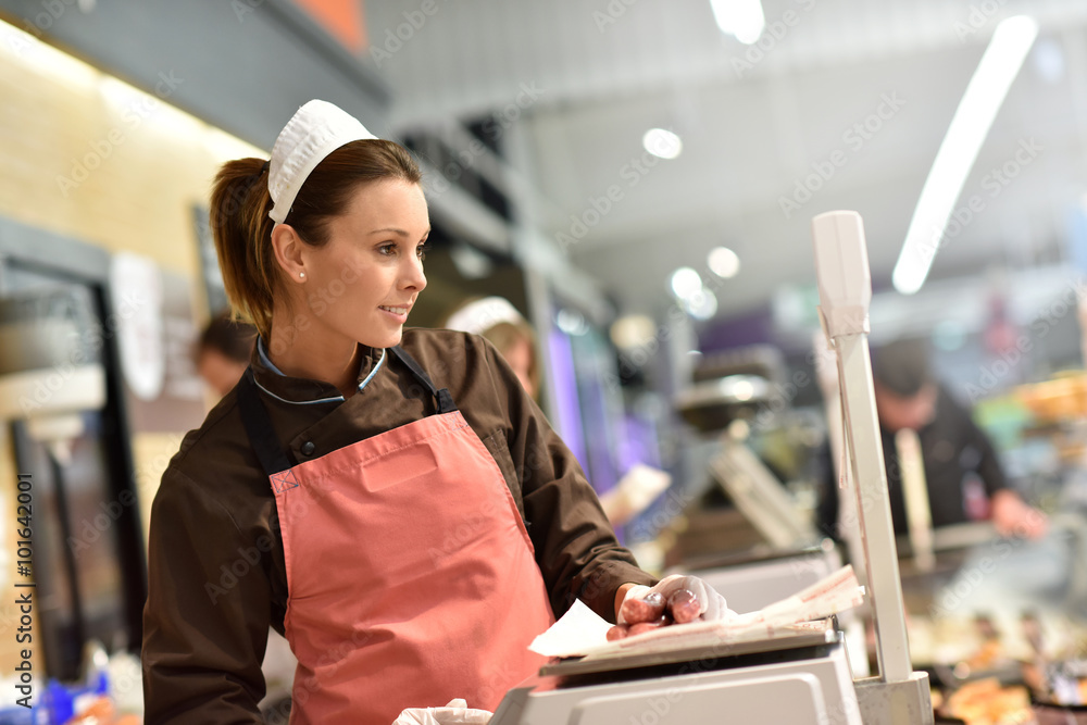 Ταπετσαρία Woman pork butcher serving sausages to customer