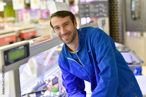 Photos Portrait of smiling fishmonger with blue uniform