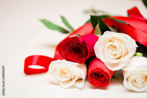 Red and white roses on a light wooden background. Women  s day 