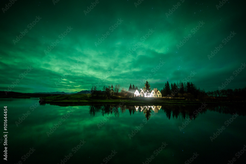 Aurora borealis above a house and trees