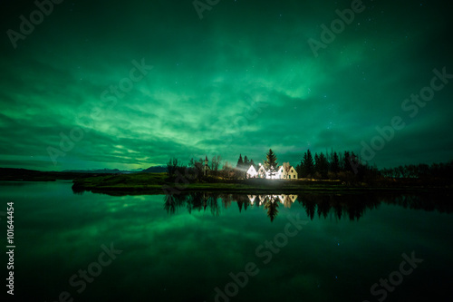 Aurora borealis above a house and trees