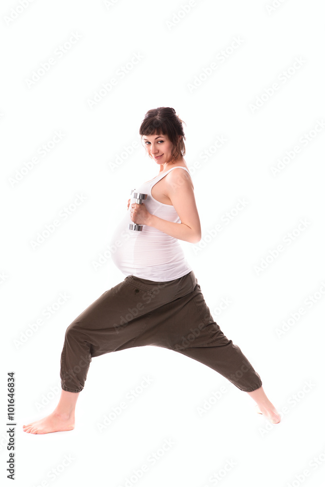 Fototapeta premium pregnant woman is engaged in gymnastics with dumbbells
