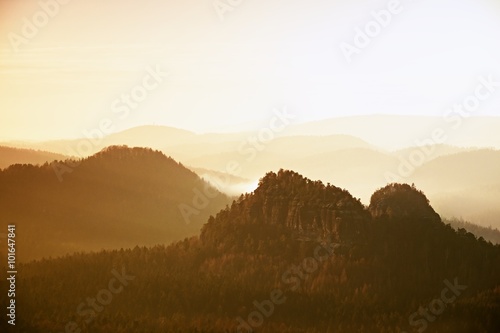 Sunrise in a beautiful mountain of Czech-Saxony Switzerland. Sandstone peaks increased from foggy background