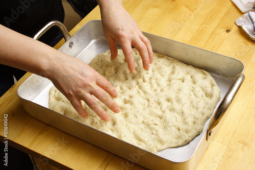 Canvas Print A woman kneading dough for Italian focaccia