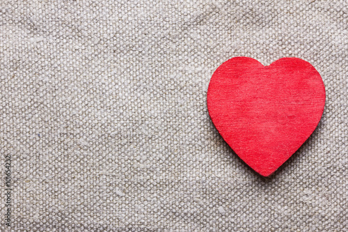 Wooden heart shape on linen fabric.