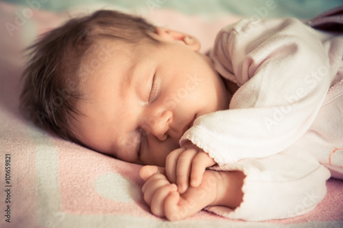 Fényképezés A portrait of a newborn baby girl sleeping  sideways