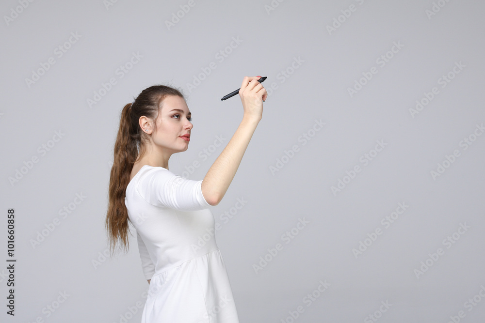 young woman with pen on grey background
