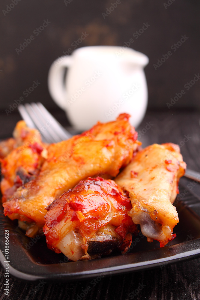 Chicken wings fried with spices in tomato sauce