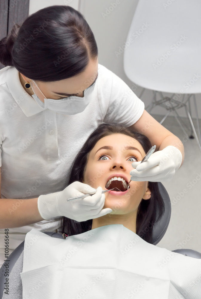 top view of a woman in the dentist's chair is looking frightened top view of a woman in the dentist's chair is looking frightened