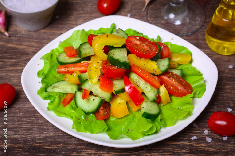 Helpful Fresh Salad of cucumbers, tomatoes, pepper and lettuce dressed with olive oil.