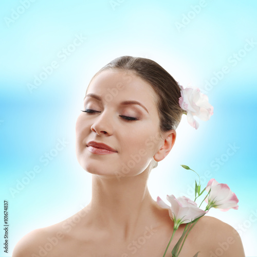 Beautiful woman enjoying with flowers on blue background