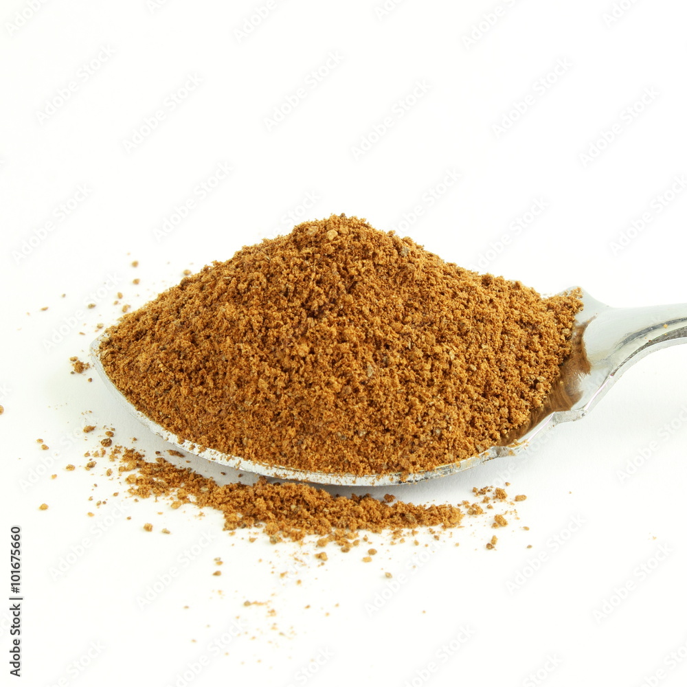 cinnamon powder closeup in spoon isolated on white background cinnamon powder closeup in spoon isolated on white background
