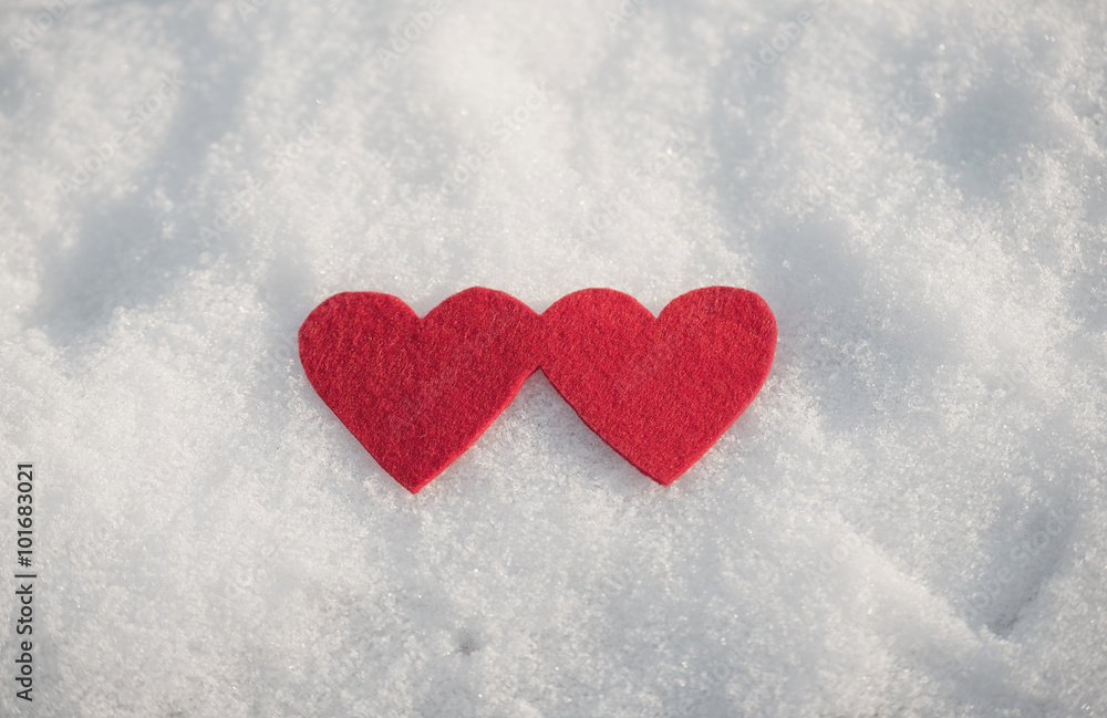 Red heart shapes on snow