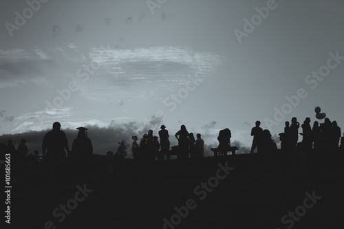 Silhouette of people relaxing at a park