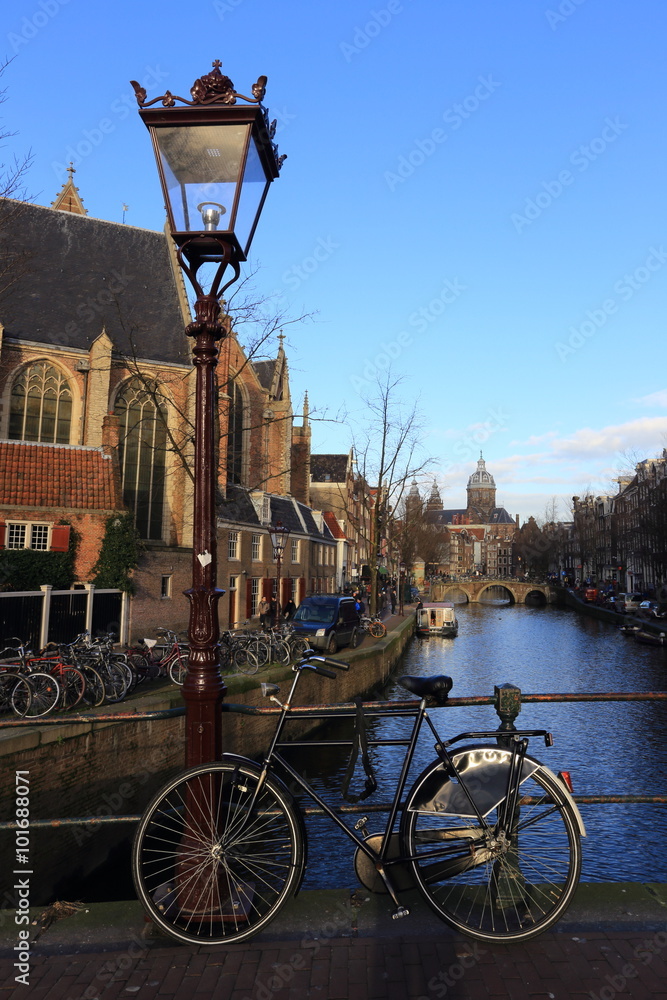 Bicycle parked on the bridge near latern overlooking a Canal in Amsterdam, Netherlands.